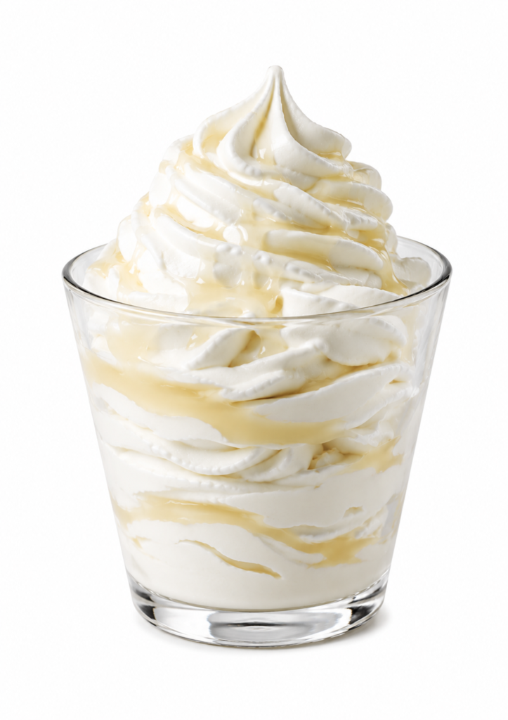 Classic vanilla shake from the Sonic shake menu topped with whipped cream and vanilla drizzle in a clear dessert glass.