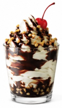 Chocolate fudge nut shake from the Sonic shake menu topped with whipped cream, chocolate syrup, chopped nuts, and a cherry in a clear glass.