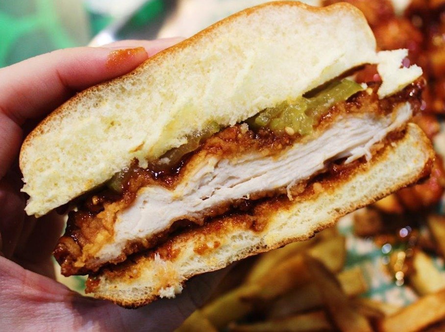 Crispy chicken sandwich with pickles served on a soft toasted bun.