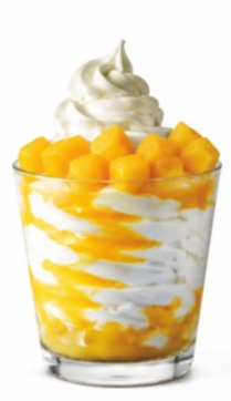 Mango shake from the Sonic shake menu topped with whipped cream and fresh mango chunks in a clear dessert glass.