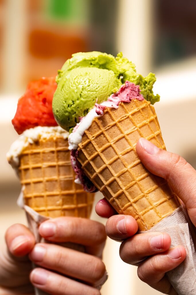 colourful waffle cones filled with assorted ice cream scoops in different flavours.